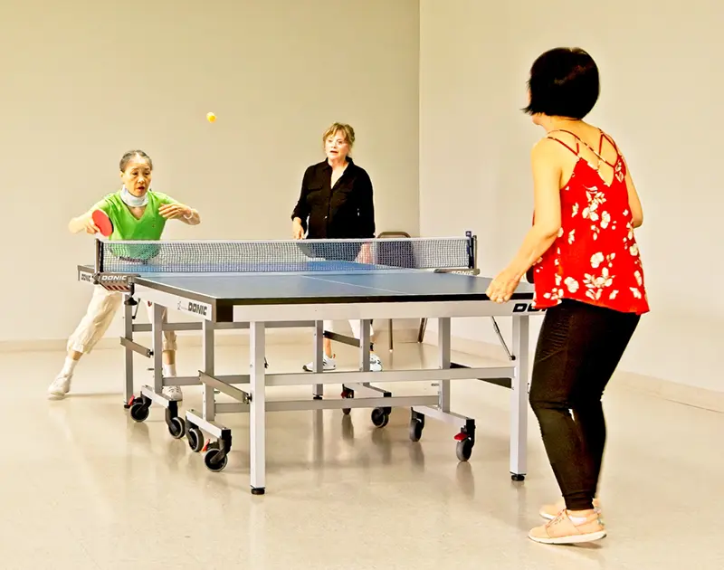 senior citizens playing ping pong at summerfield retirement community in tigard, oregon