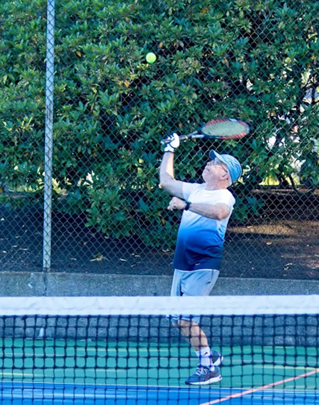 senior playing tennis at summerfield retirement community in Tigard, Oregon